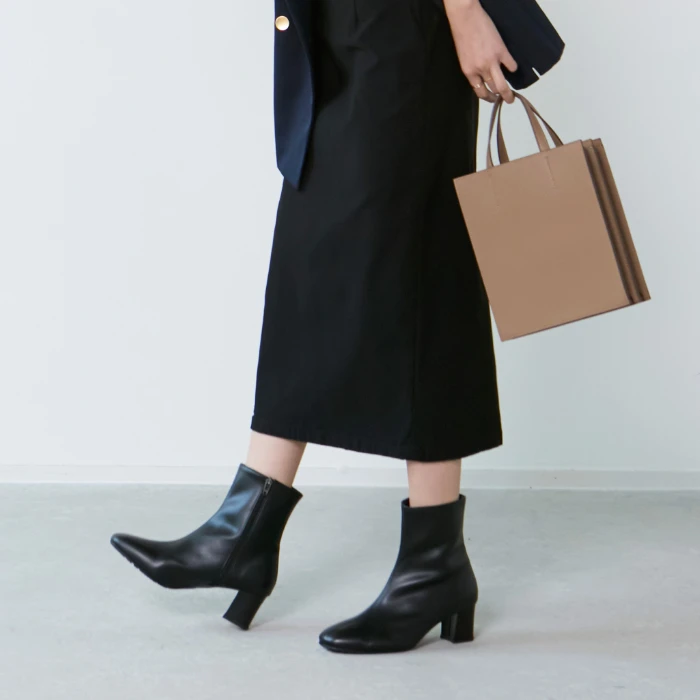 整体ブーツ（ブラック）を履く女性の足元