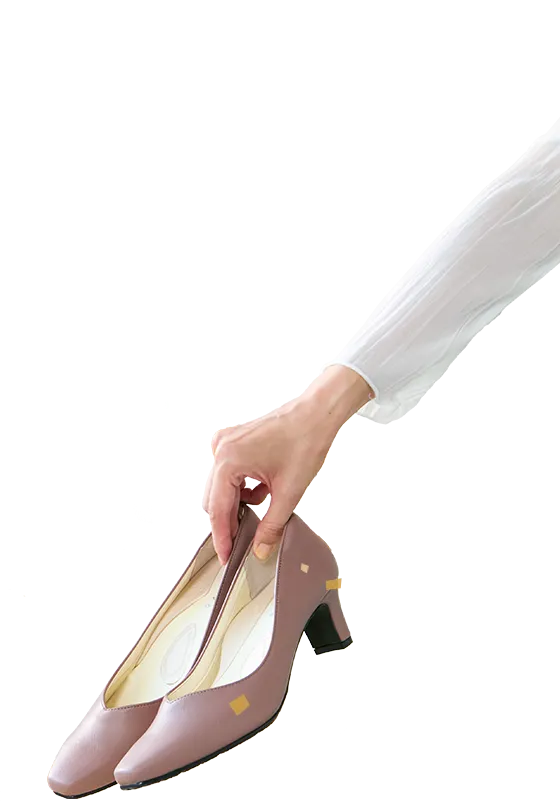 カラー整体パンプスを持つ女性の手元